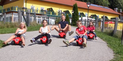 Naturhotel - Kinderbetreuung - Bobbycar fahren im Spätsommer - Bio-Bauernhof Petschnighof