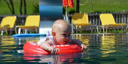 Naturhotel - Wassersparmaßnahmen - Naturarena - Kleinkind im Pool des Bio-Kinderhotels - BIO-Kinderhotel Kreuzwirt