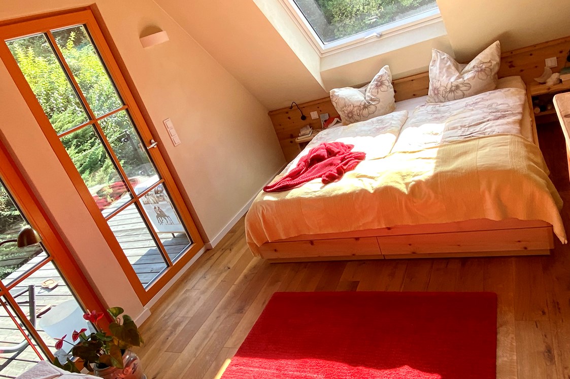 Biohotel: Ferienhaus "Rosenscheune", Schlafzimmer für 2 Personen im Obergeschoss, mit Sonnenterasse für Yoga und Chillout - BIO-NATURIDYLL WIESENGRUND