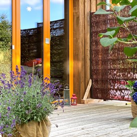 Biohotel: Ferienhaus "Rosenscheune", Terrasse zum Garten im Zwischengeschoss - BIO-NATURIDYLL WIESENGRUND
