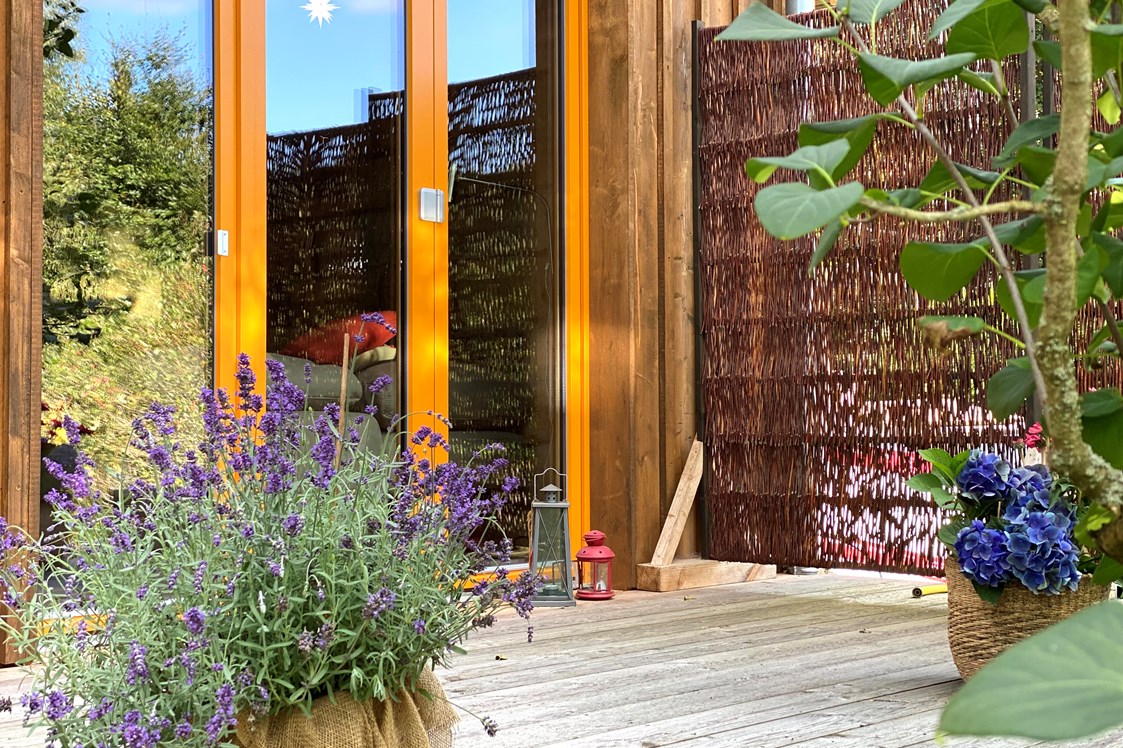 Biohotel: Ferienhaus "Rosenscheune", Terrasse zum Garten im Zwischengeschoss - BIO-NATURIDYLL WIESENGRUND