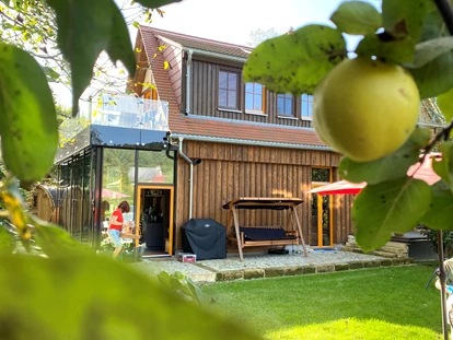 Naturhotel - Mitarbeiterbetreuung: Überdurchschnittliche Bezahlung - Dohma - Ferienhaus "Rosenscheune", Blick aus dem rückwärtigen Garten - BIO-NATURIDYLL WIESENGRUND