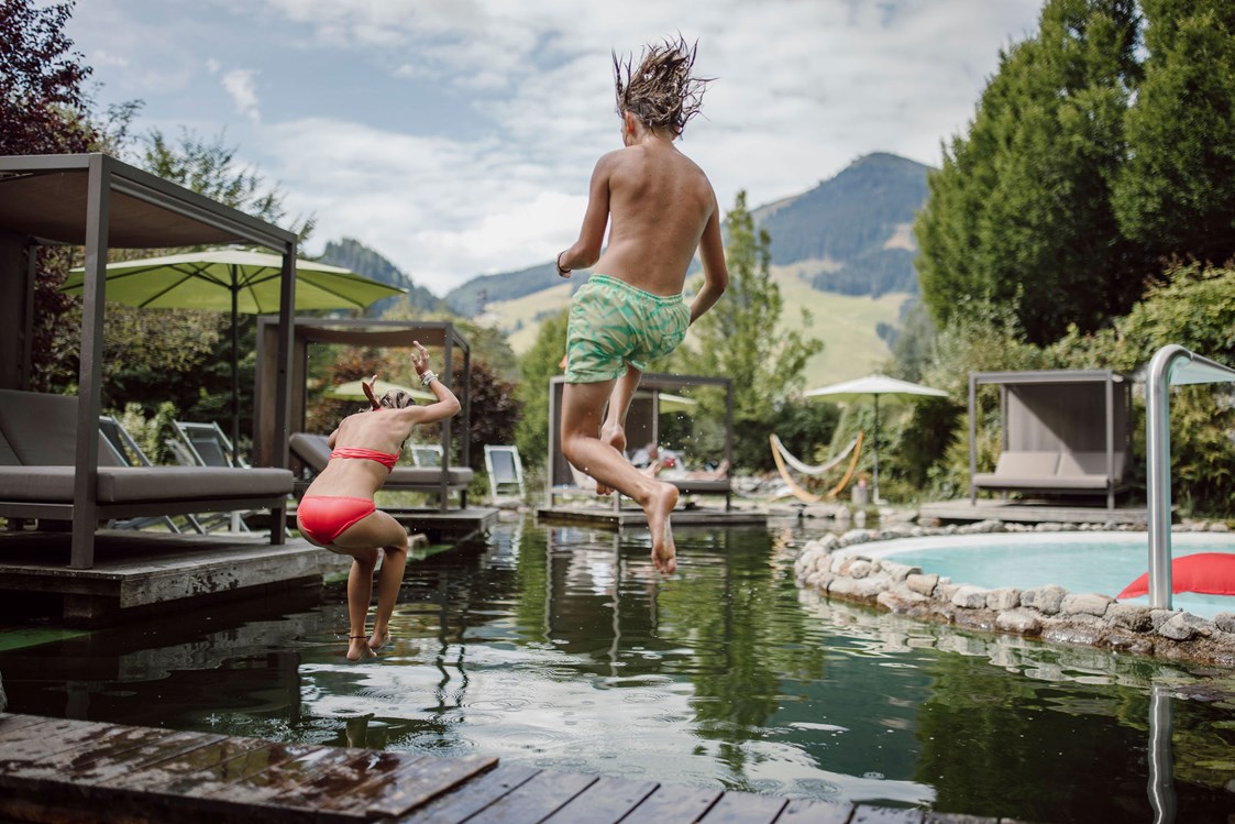 Biohotel: Jump in den erfrischenden Schwimmteich - Gartenhotel Theresia****S - DAS "Grüne" Familienhotel in Saalbach-Hinterglemm 