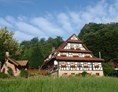 Naturhotel: Hausansicht: Der "Holzwurm" im Grünen - Naturhotel Holzwurm
