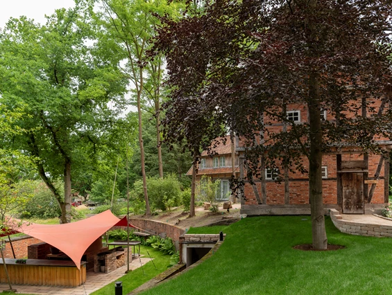 Biohotel: Unser Rotes Segel, etwas tiefer gelegen bietet einen tollen Platz für die Outdoor Küche. Hier wird im Lehmofen gebacken, im Räucherofen geräuchert und es gibt BBQ vom Grill. Im Sommer findet hier am Sonntag das Sonntagsvergnügen statt mit selbstgemachten Leckereien. - Biohotel Wildland