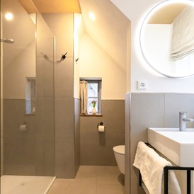 Biohotel: Unsere Badezimmer bieten ganz viel Ablagefläche und Stauraum. Sie sind modern und dennoch fügen sie sich harmonisch in das traditionelle Haus ein - Biohotel Wildland 