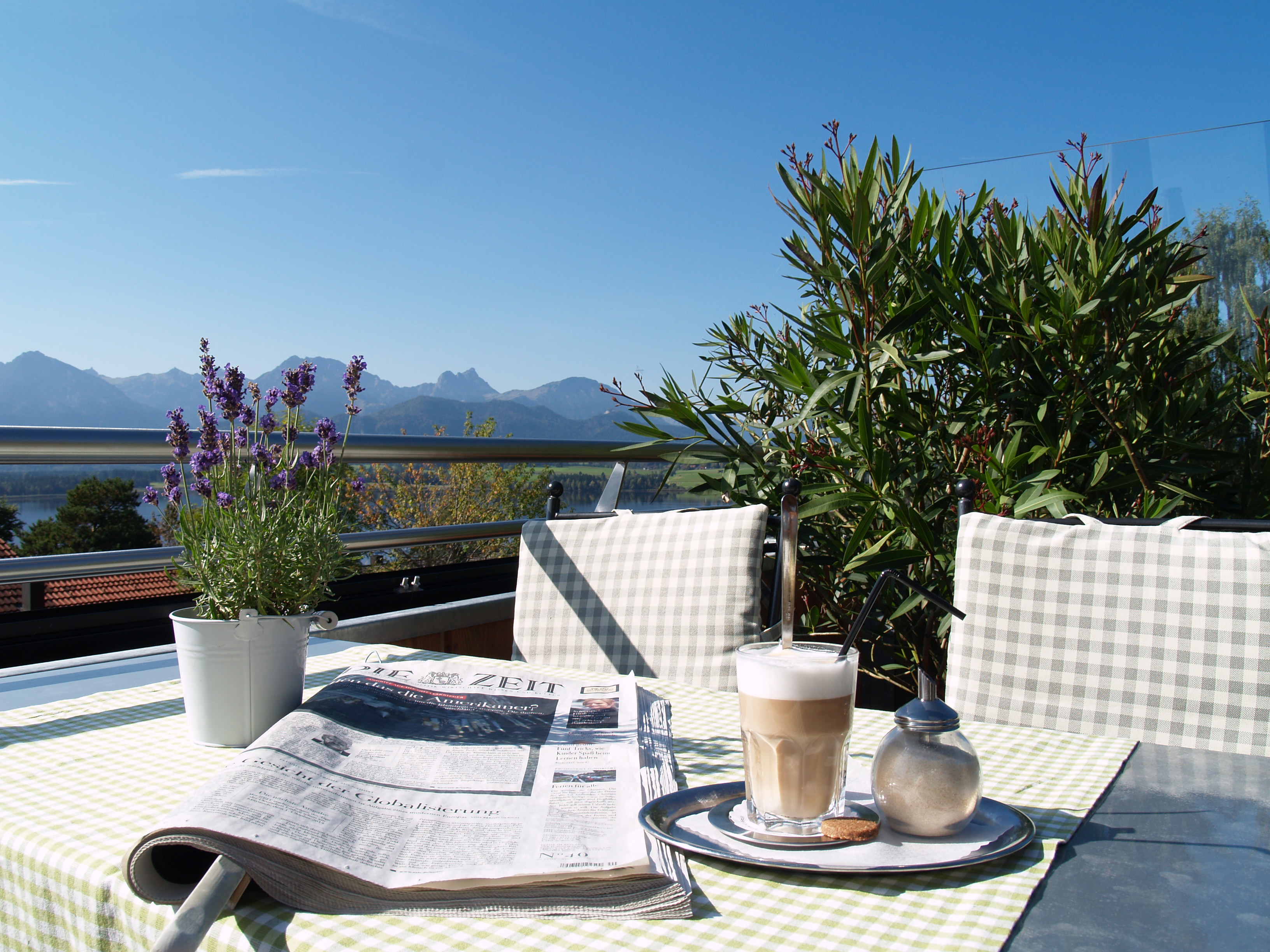 Biohotel: Bio-Genuss mit Weitblick auf der Panoramaterrasse des Biohotels Eggensberger: Entspannung bei Latte Macchiato und aktueller Zeitung mit herrlichem Blick über den Hopfensee bis zu den Allgäuer Alpen. - Biohotel Eggensberger
