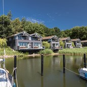Naturhotel: Die Uferhäuser erstrecken sich entlang unseres Hafens in Gustow auf Rügen - im-jaich Naturoase Gustow