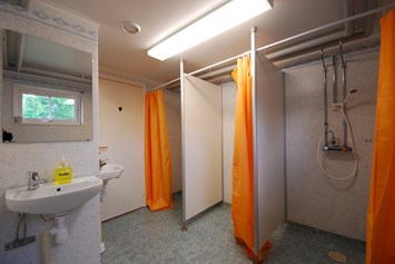 Biohotel: Sanitäranlage mit Duschen und Waschbecken. - Lilla Sverigebyn
